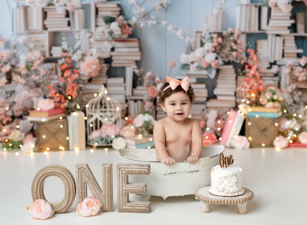 Baby girl in vintage bath tub on chapter one cake smash set.