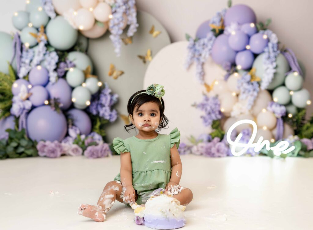 Baby girl eating birthday cake and getting messy.
