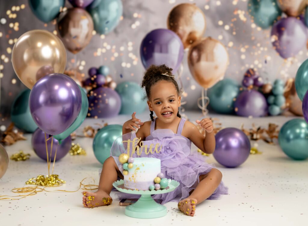 Toddler girl eating cake and smiling.