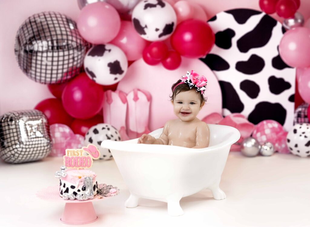 baby laughing in bath tub in front of cake smash cowgirl set.