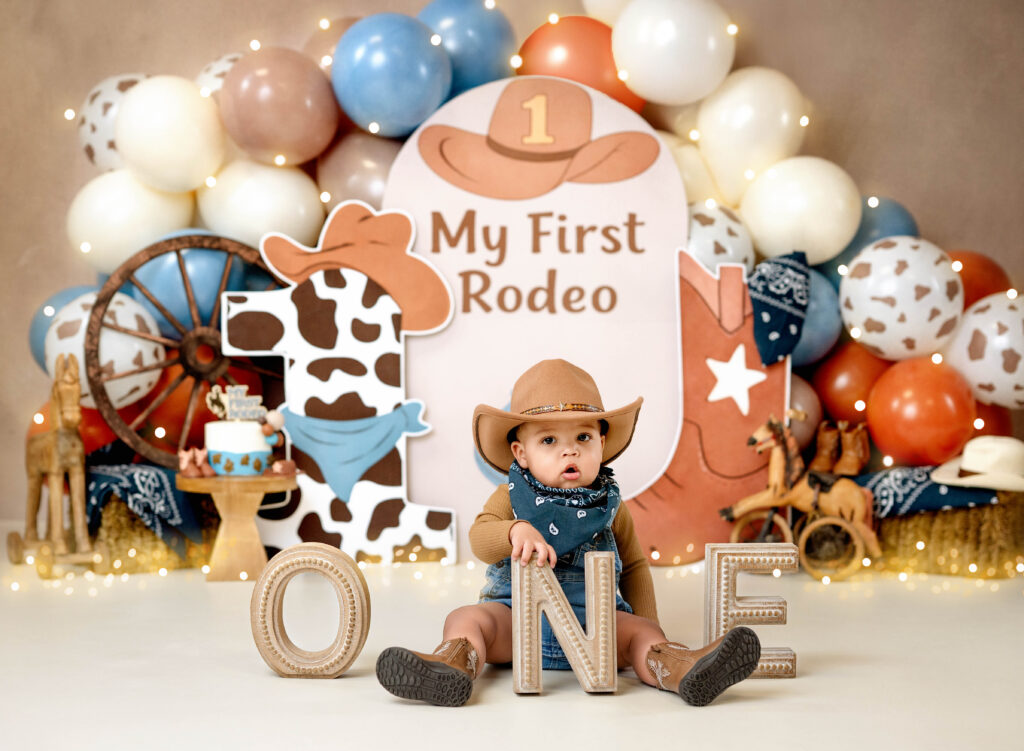 Little boy holding ONE letters for 1st rodeo cake smash.