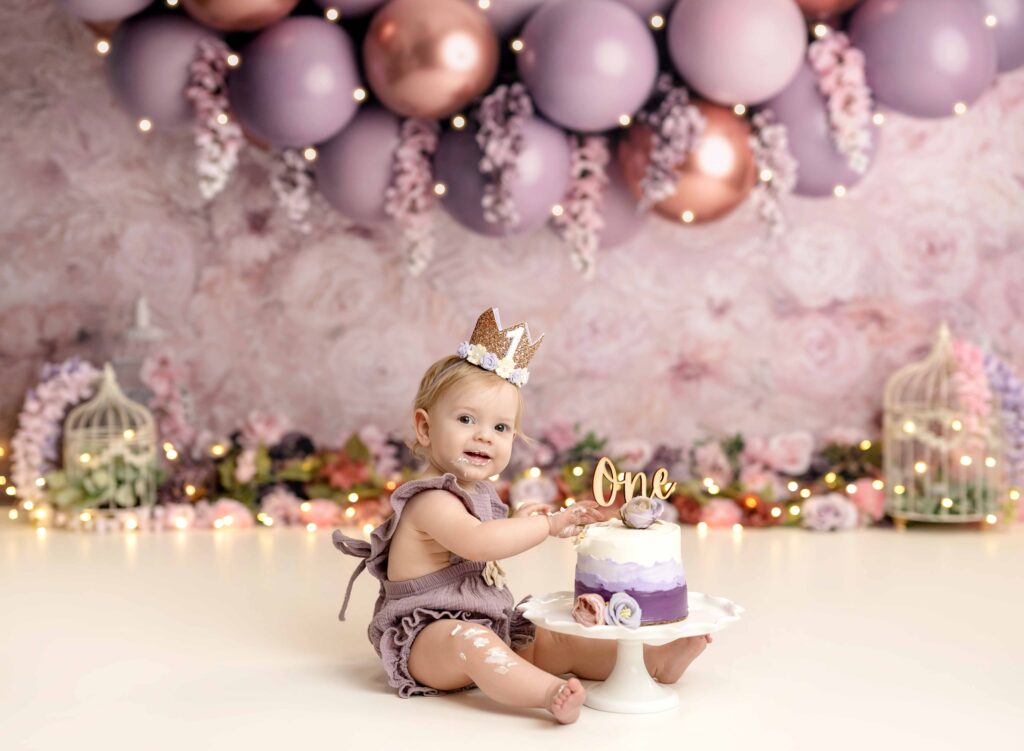 Baby girl eating cake on Atlanta cake smash set.