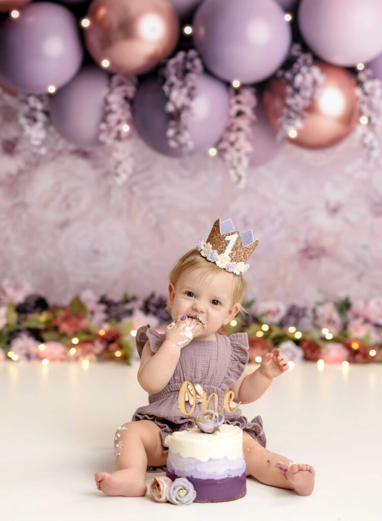 Baby girl eating cake on Atlanta cake smash set.