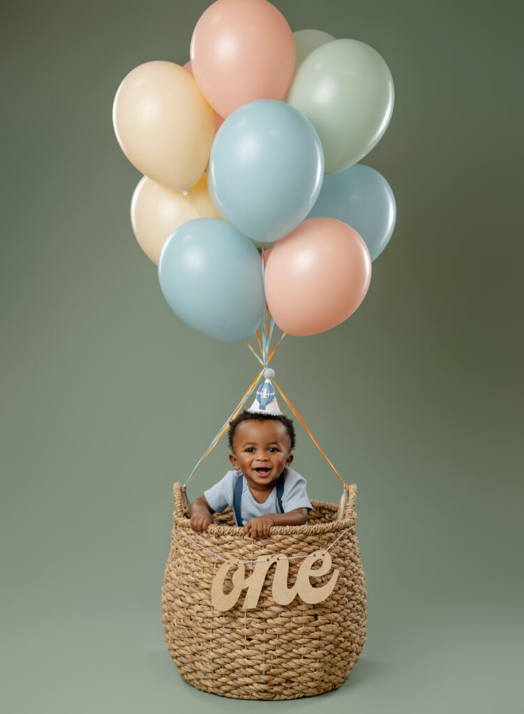 baby boy in basket of balloons