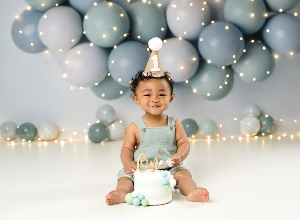 Baby boy having fun eating cake for his cake smash birthday photoshoot.