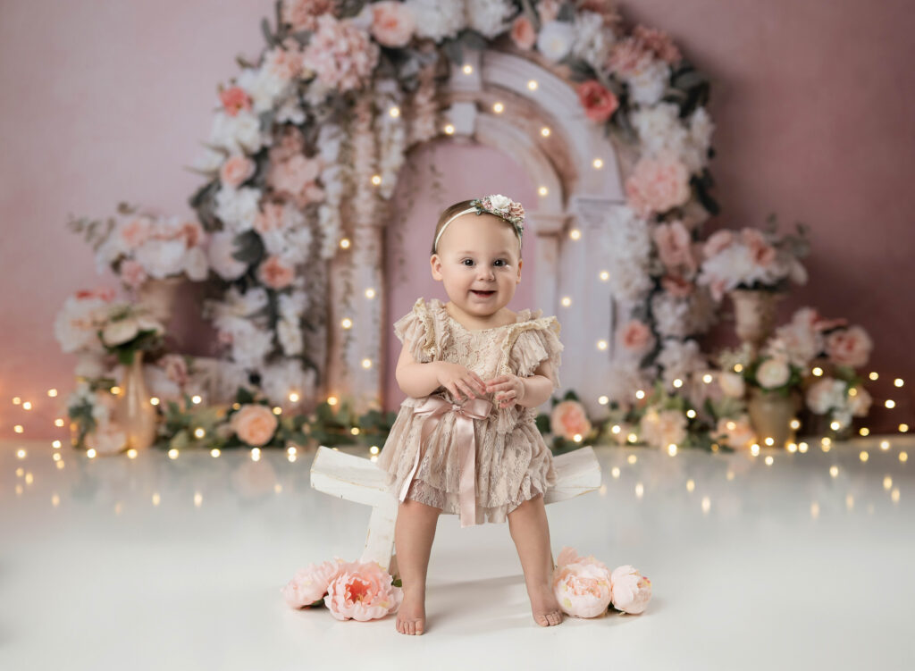 floral arch with baby girl smiling