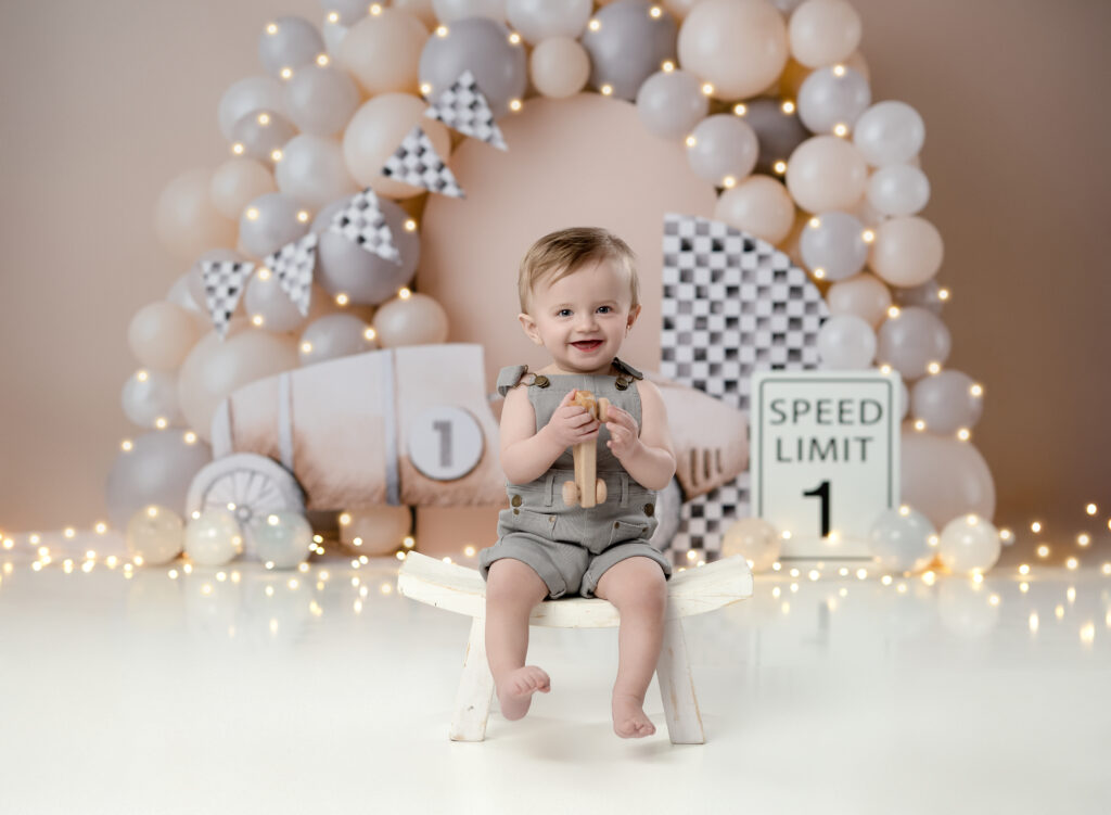 boy sitting on stool and smiling for 1st birthday photo in Atlanta.