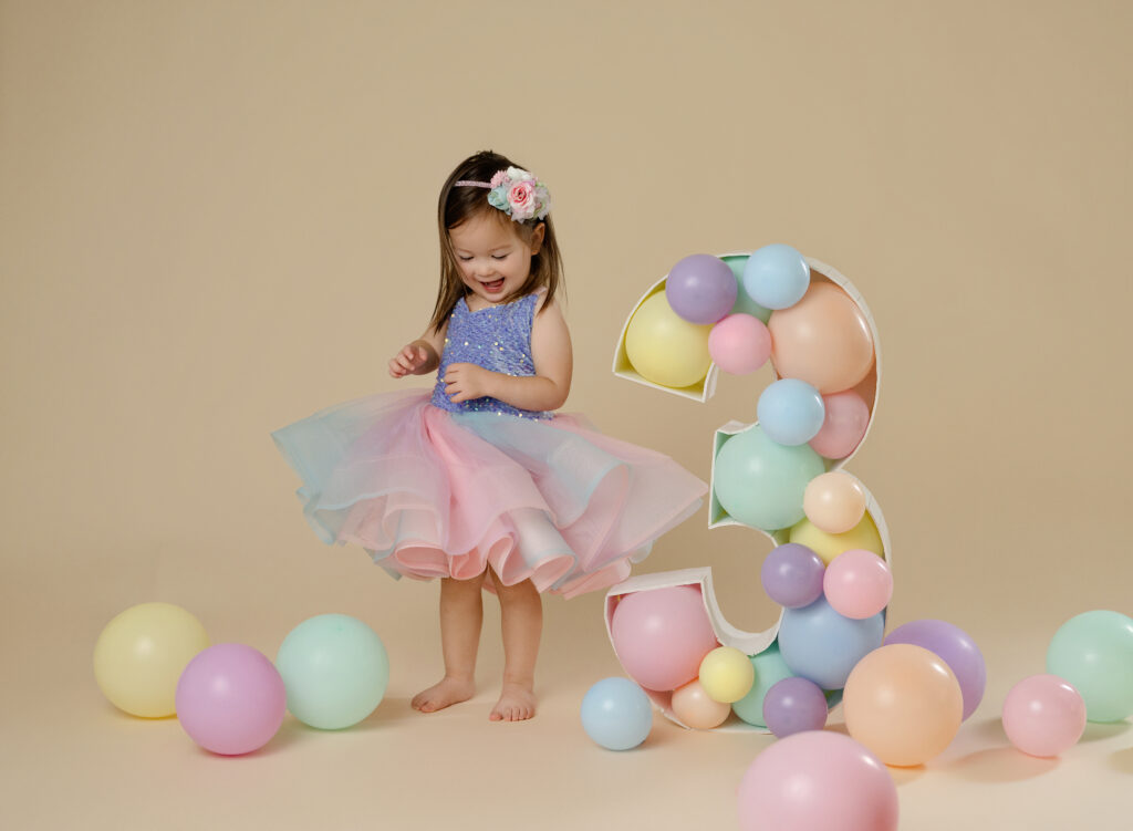 toddler girl twirling her dress during her birthday photoshoot at Atlanta studio.