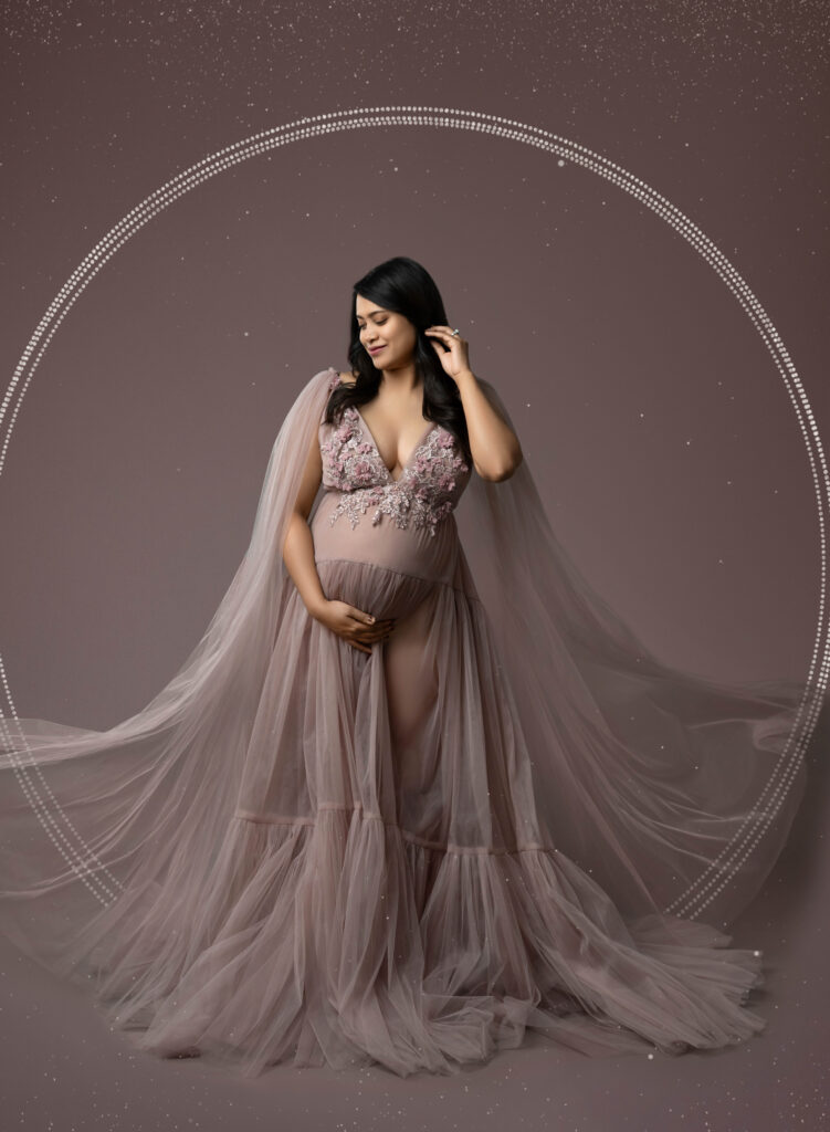 Pregnant women in mauve dress, holding her baby bump.