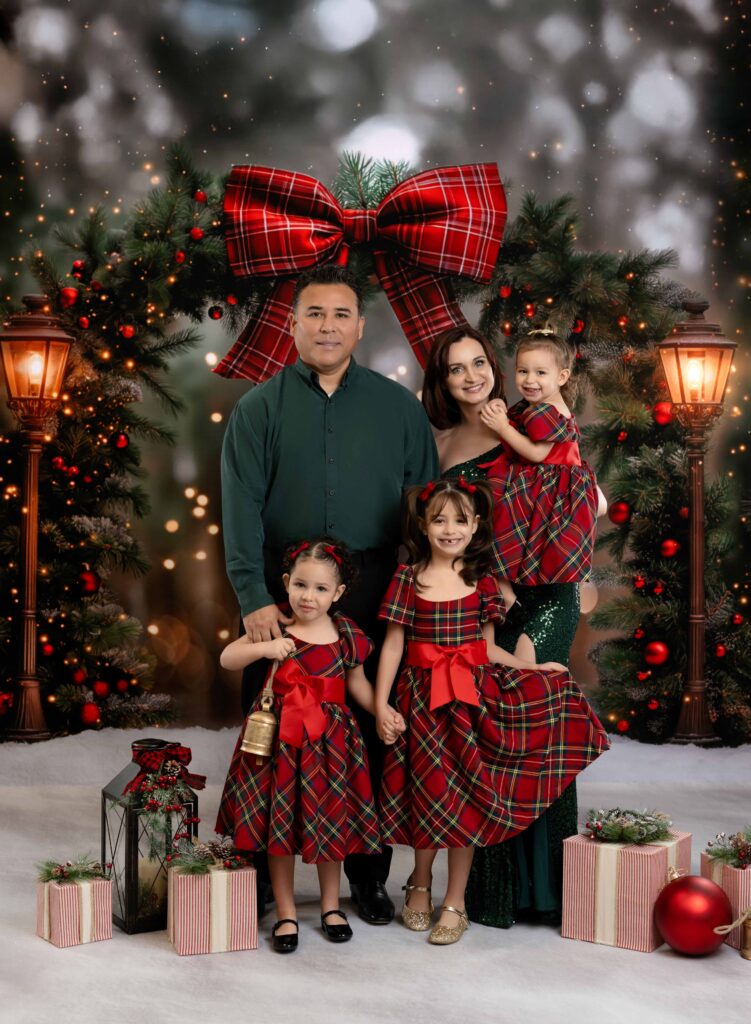 family in red plaid and green taking holiday photos in studio.