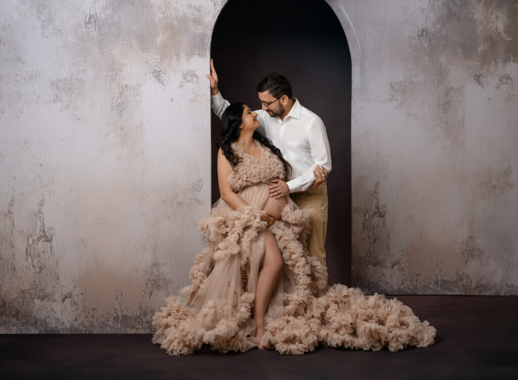Mom and Dad posing under arch for maternity photos. Atlanta Maternity Photographer.