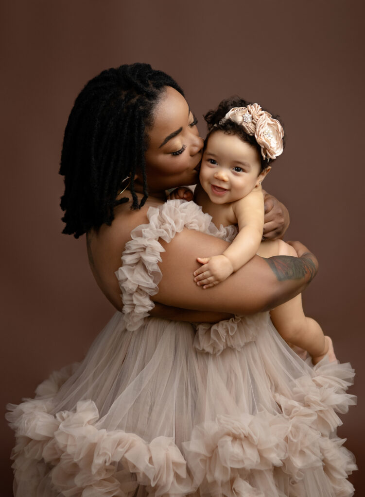 Mom kissing baby for a milestone photo. Atlanta Baby Photographer.