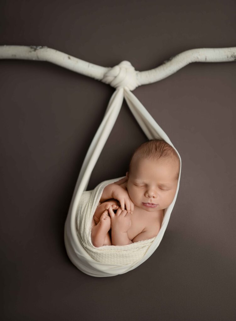 baby sleeping in a wrapped cocoon from hanging branch