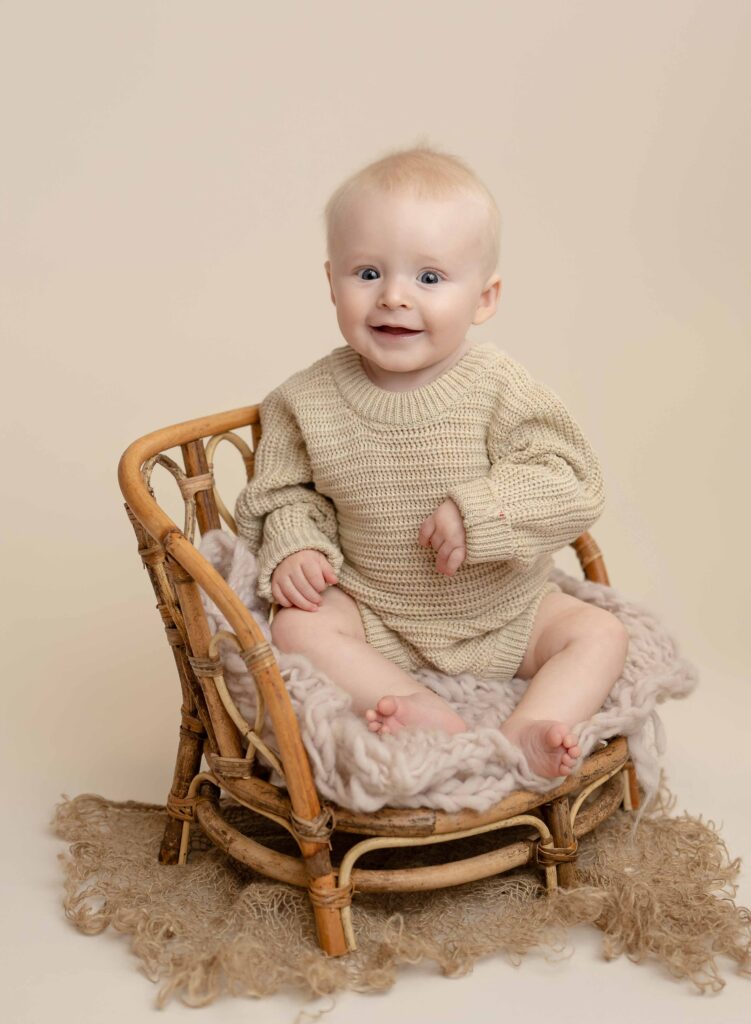 Baby boy sitting in bamboo chair.
