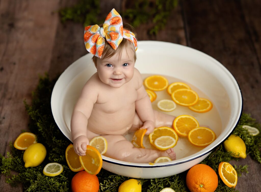 Baby girl in tub with fresh fruit, oranges and lemons. Mini session fruit bath taken at Atlanta photo studio by Jenni Nikki Photography.