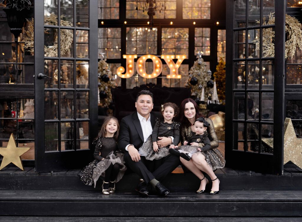 Family of 5 dressed in black and gold taking outdoor Christmas photos near Atlanta.