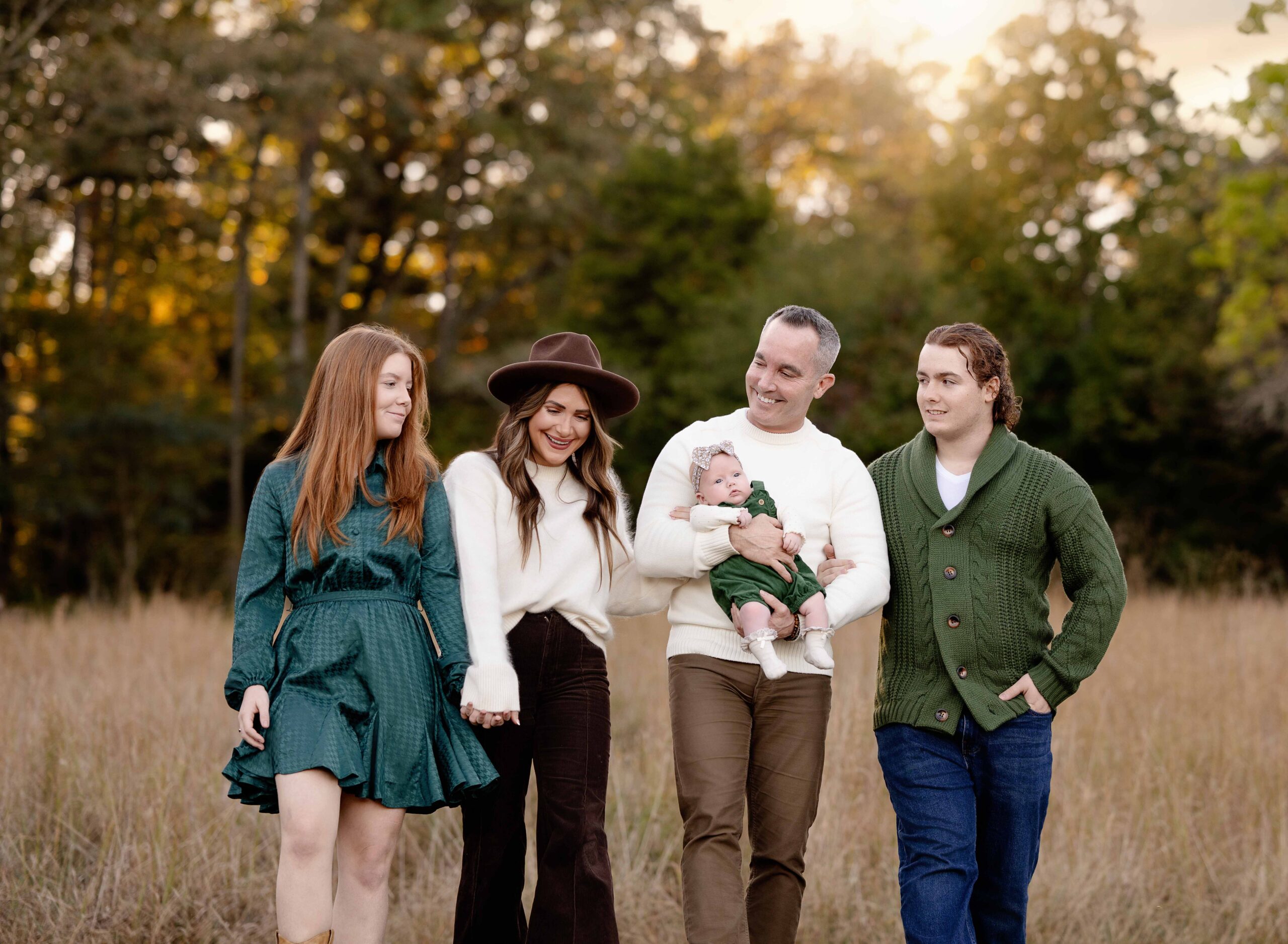 Family of 5 walking in hay field, taking fall photos.