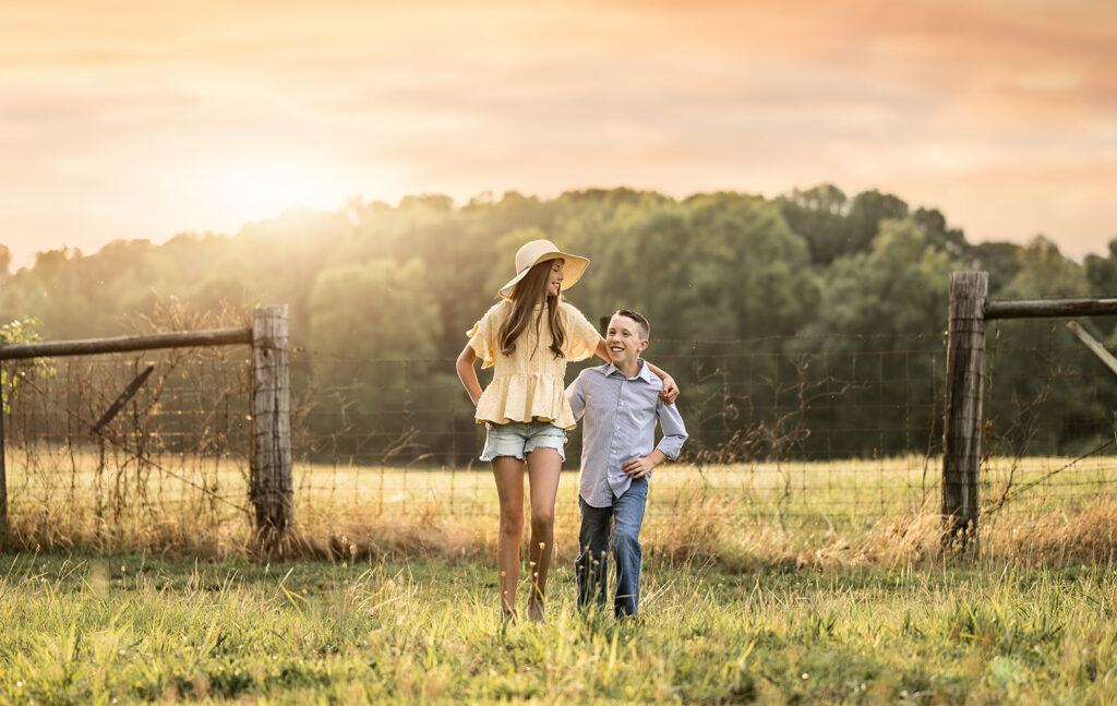 Atlanta child photographer taking photos of siblings in an open field.