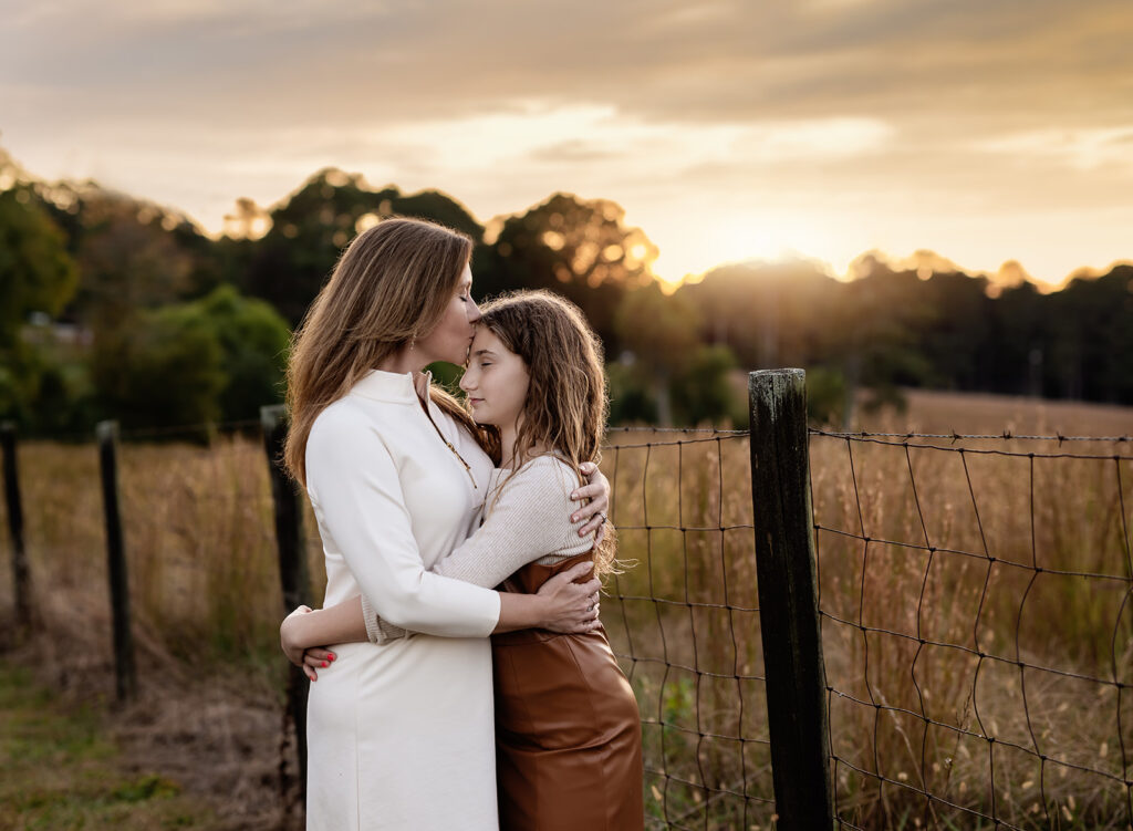 Mom kissing daughter on forehead.