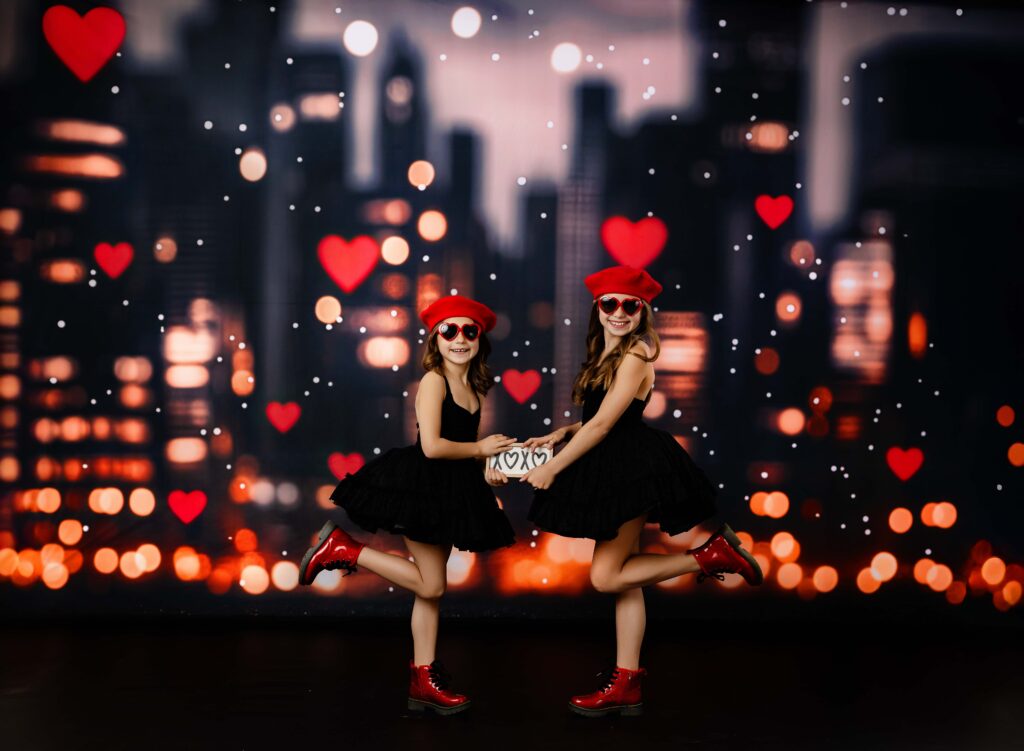 Love in the City mini session with Jenni Nikki Photography. Two girls in black dresses, red boots and red hats holding a valentines day sign.