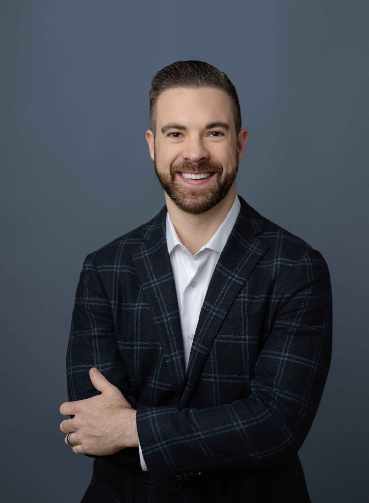 Man with plaid sports coat on, arms crossed and smiling at camera for his Atlanta business headshot.